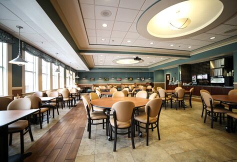 Spacious dining room with round tables and beige chairs