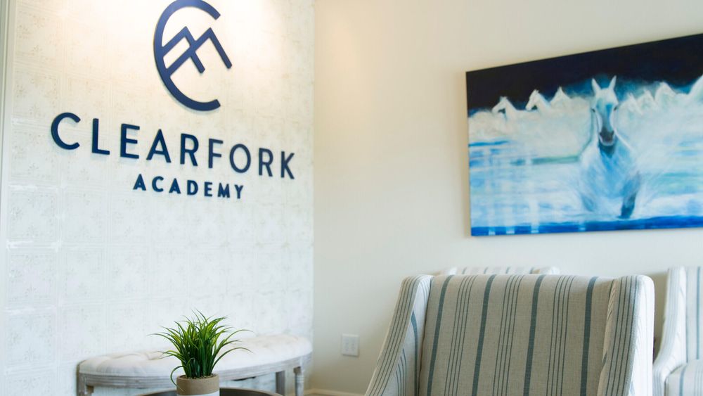 Seating area with logo on wall and plant decor