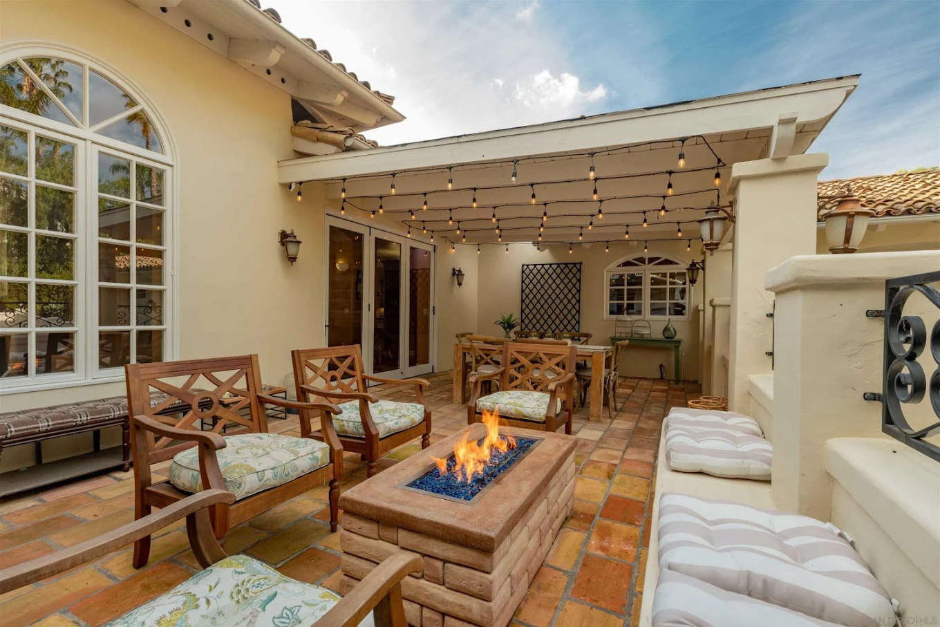 Patio seating area with fire pit and string lights