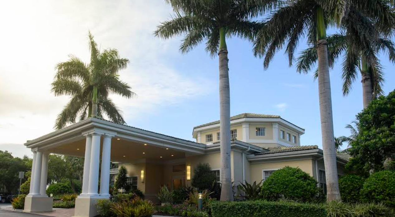 Palm-lined exterior with grand entrance and white columns