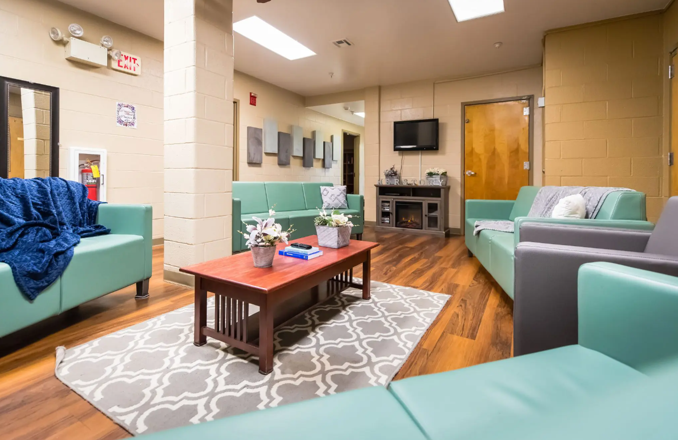 Comfortable lounge with couches, coffee table, and wall TV