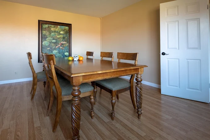 Wooden dining table with six chairs and fruit centerpiece