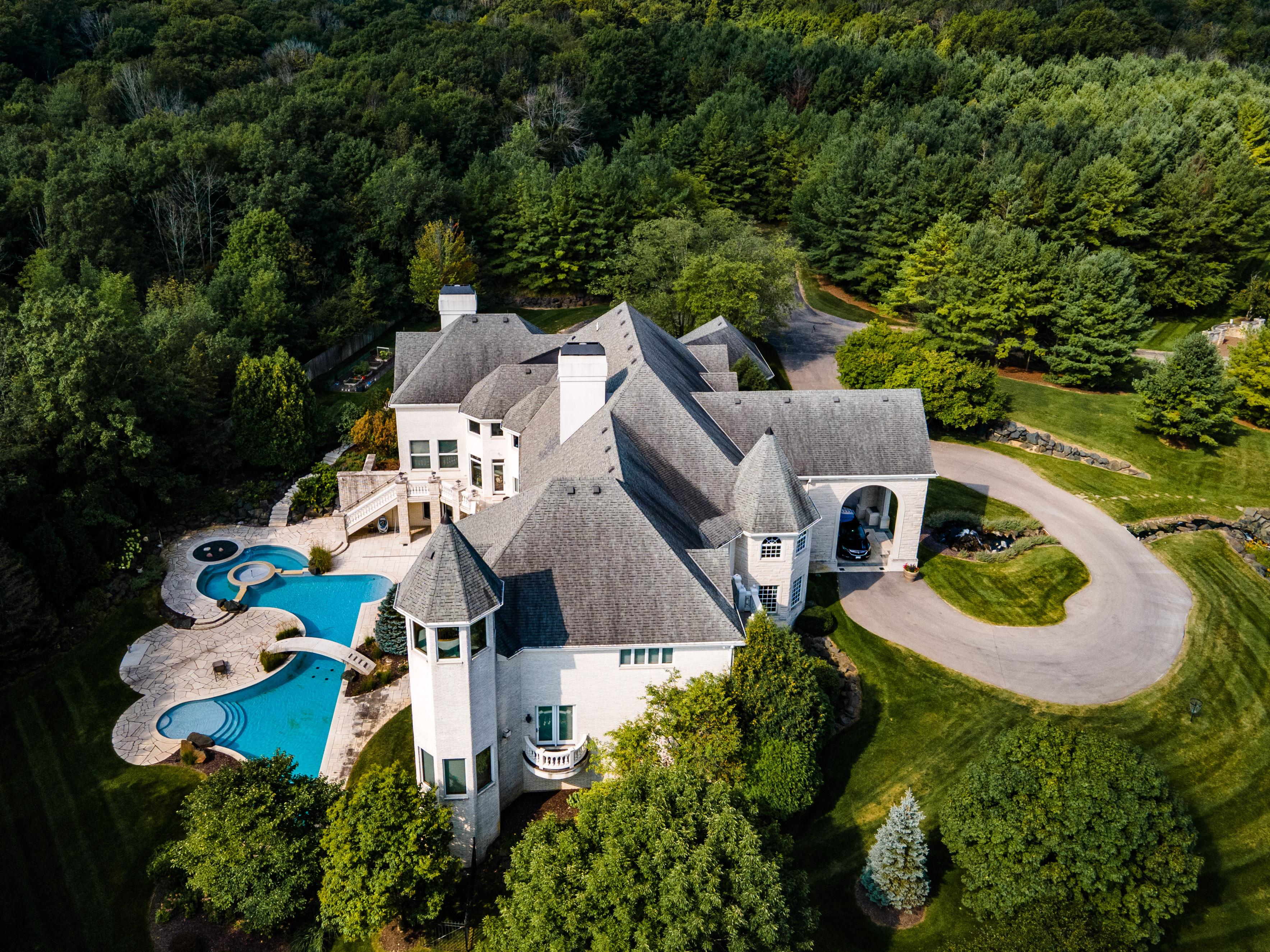 Aerial view of a a mansion rehab facility surrounded by a forest.