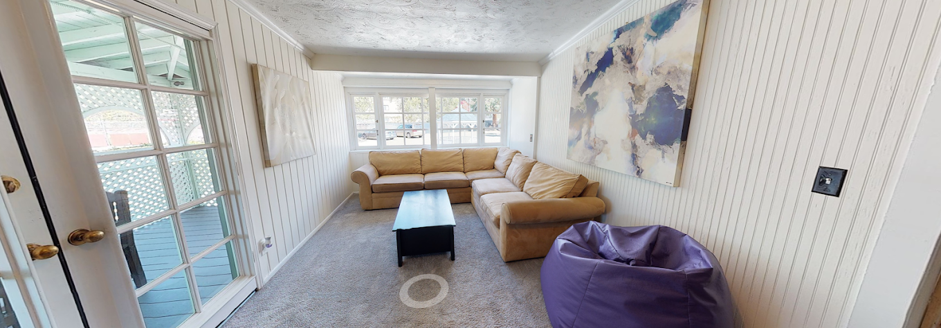 Bright living room with sofas and patio access at recovery center