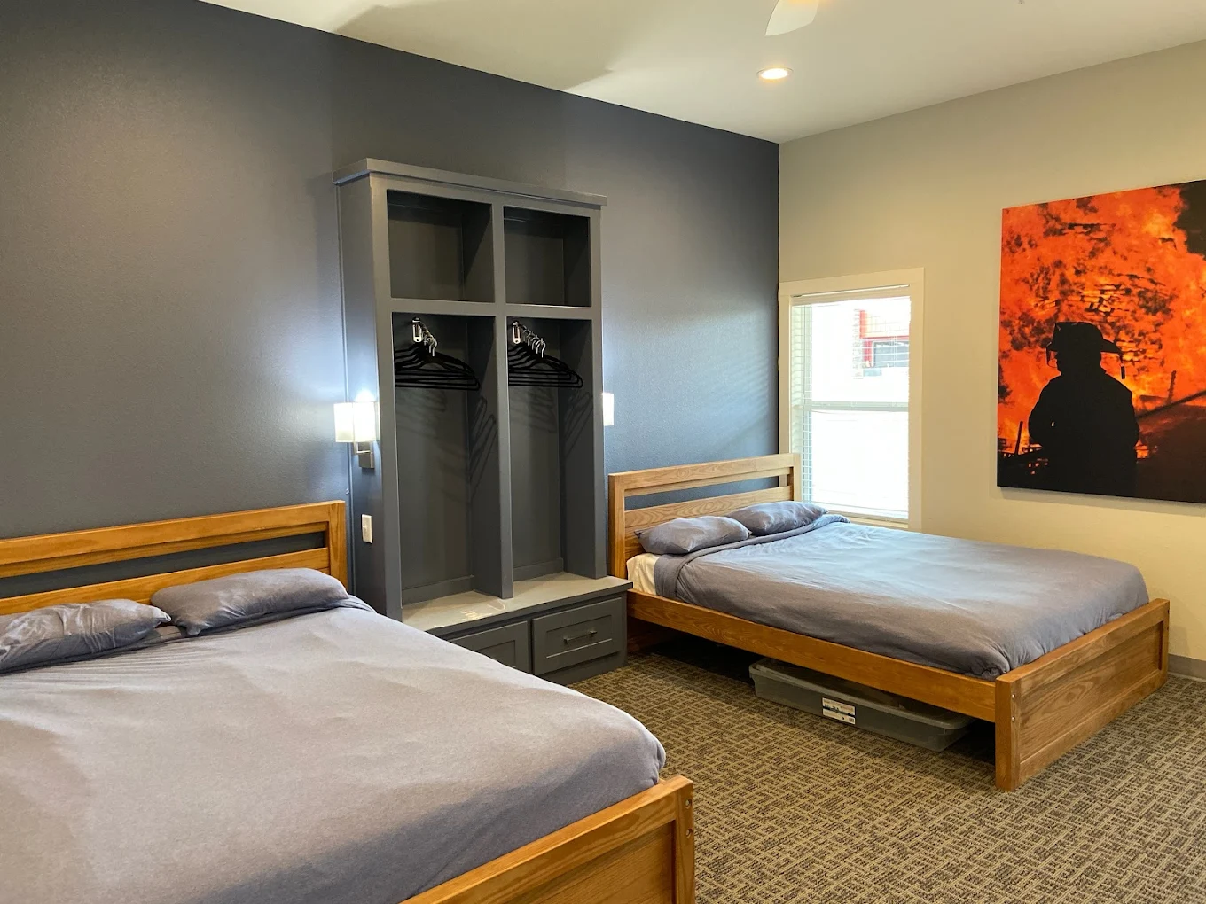 Two twin beds with open closets and wall art