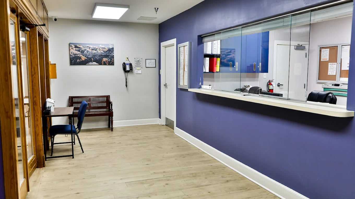 Reception window with purple accent wall and seating area