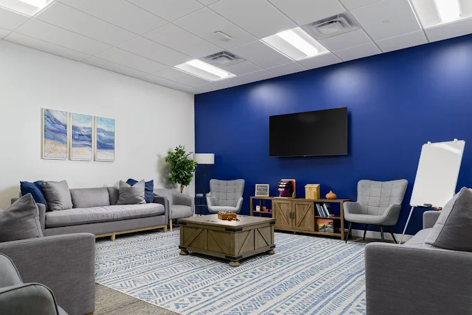 Lounge with sofas, armchairs, and wall-mounted TV