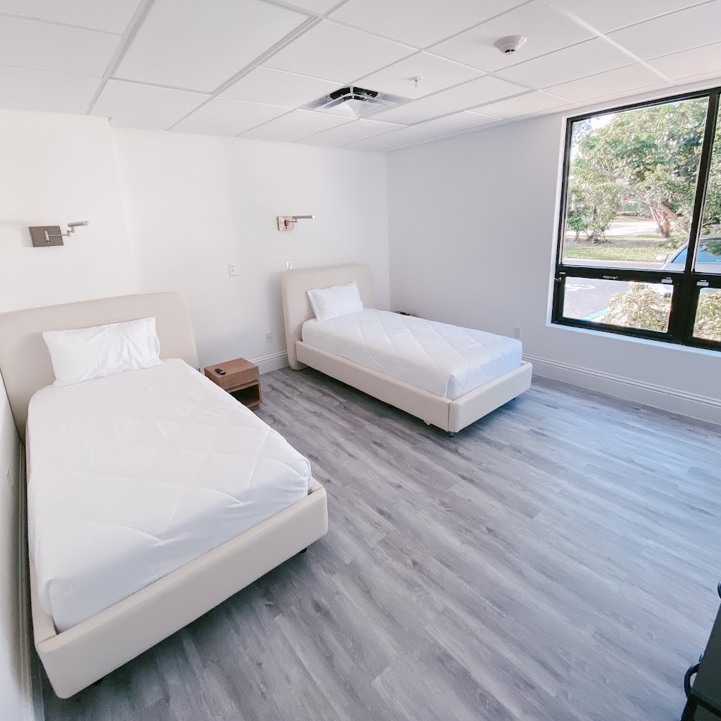 Shared bedroom with two beds and a large window.