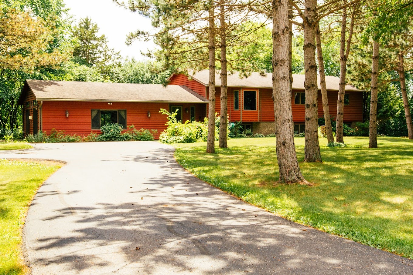 Driveway and trees beside red rehab center building