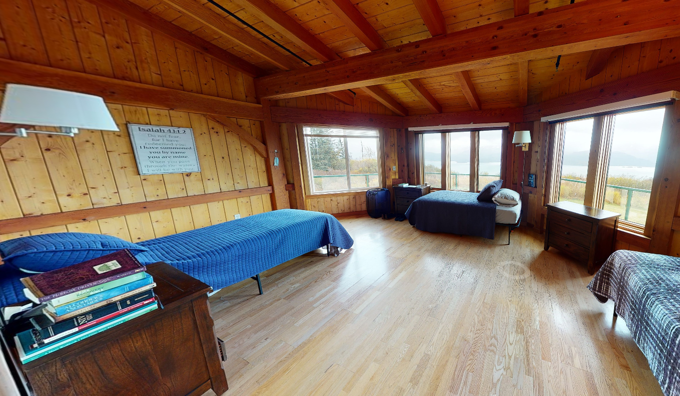 Shared bedroom with single beds and large windows overlooking nature