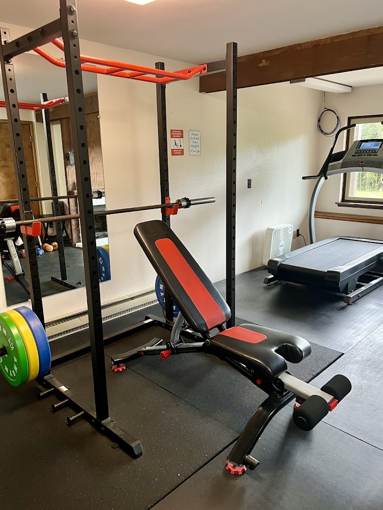 A rehab gym with weightlifting equipment and a treadmill.