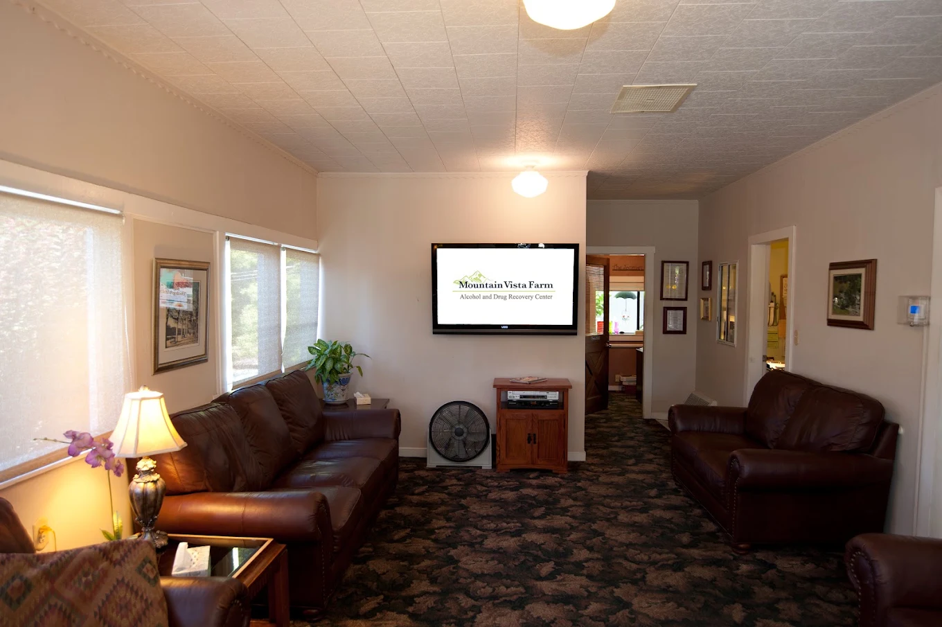 Bright indoor common area with seating and framed wall art