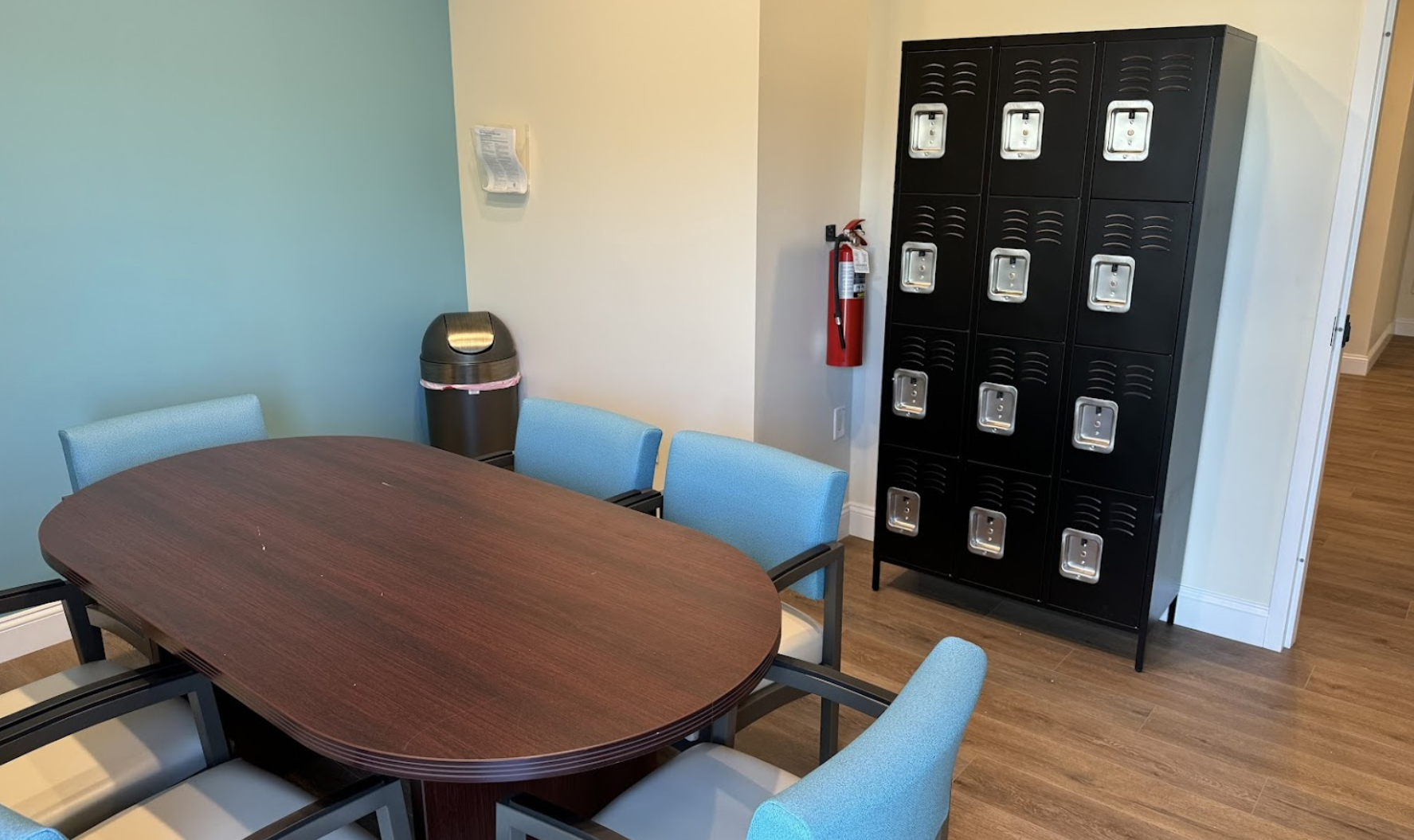 Meeting room with table, chairs, and lockers in back