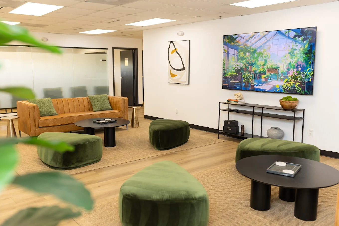Lounge with sofas, ottomans, tables, and colorful wall art
