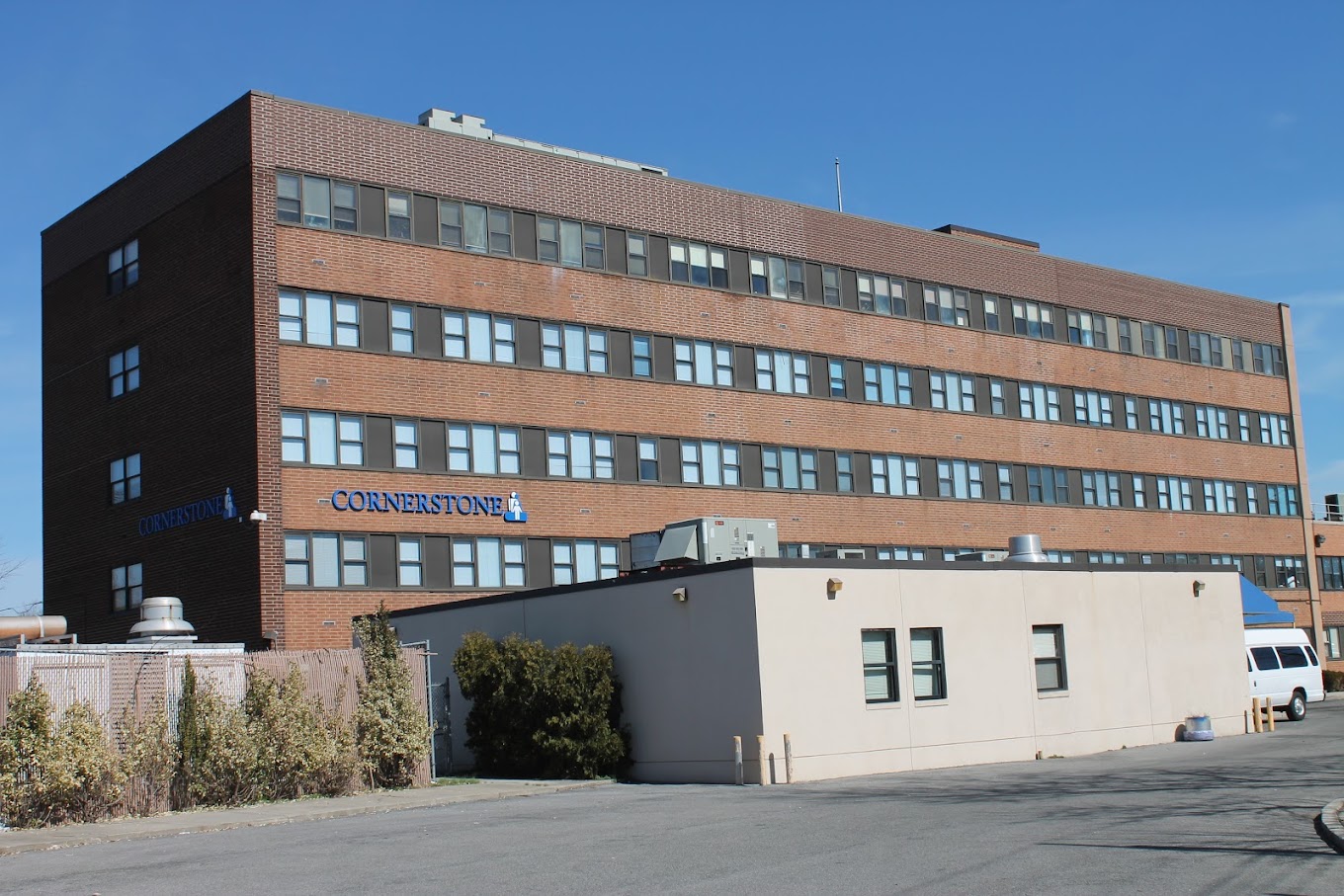 Multi-story rehab facility with brick and white facade