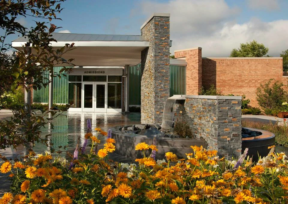 Building entrance with water feature and flower garden