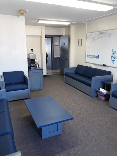 Common room with blue couches and wall TV
