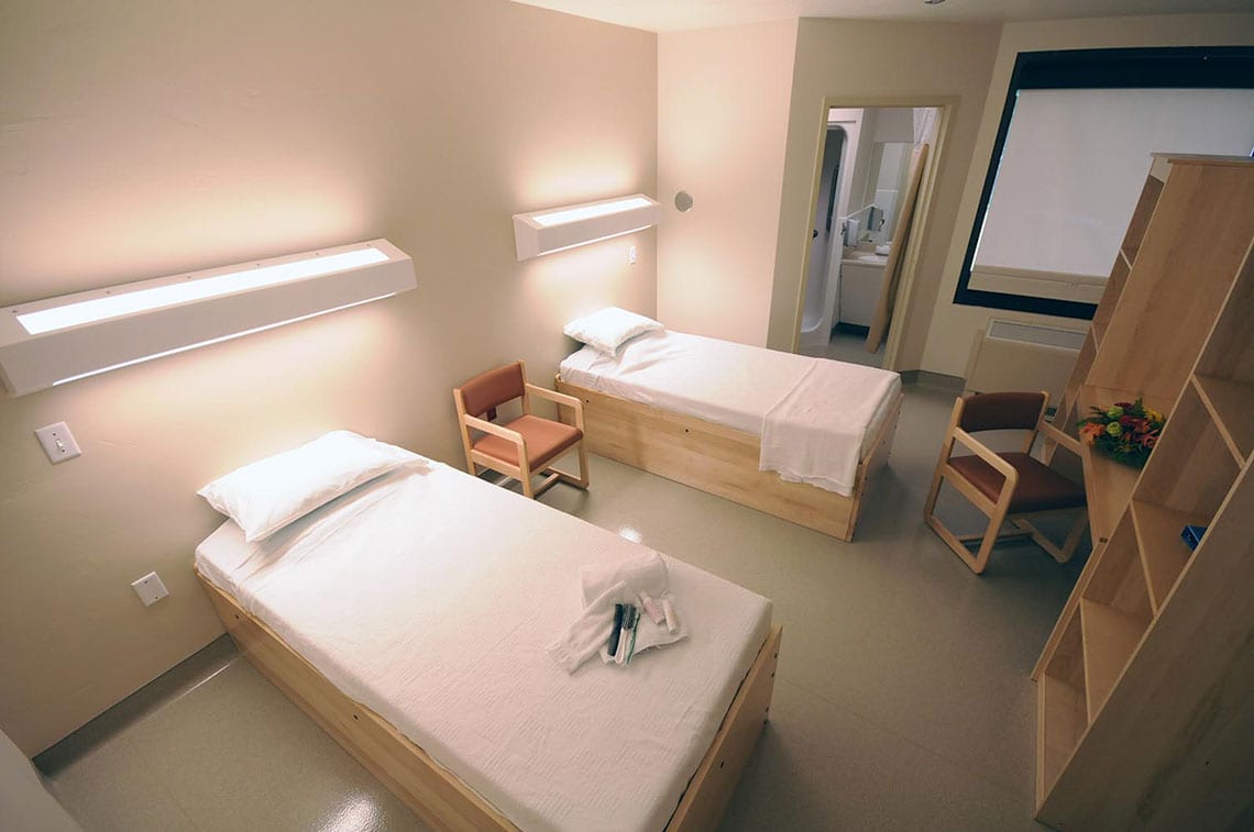 Twin beds with built-in desks and attached restroom