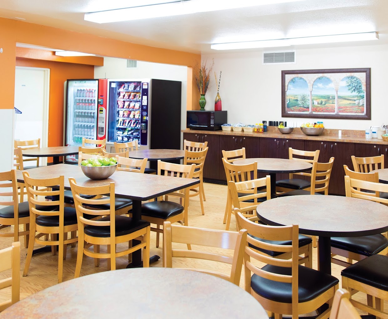 Dining area with wood tables, chairs, and vending machines