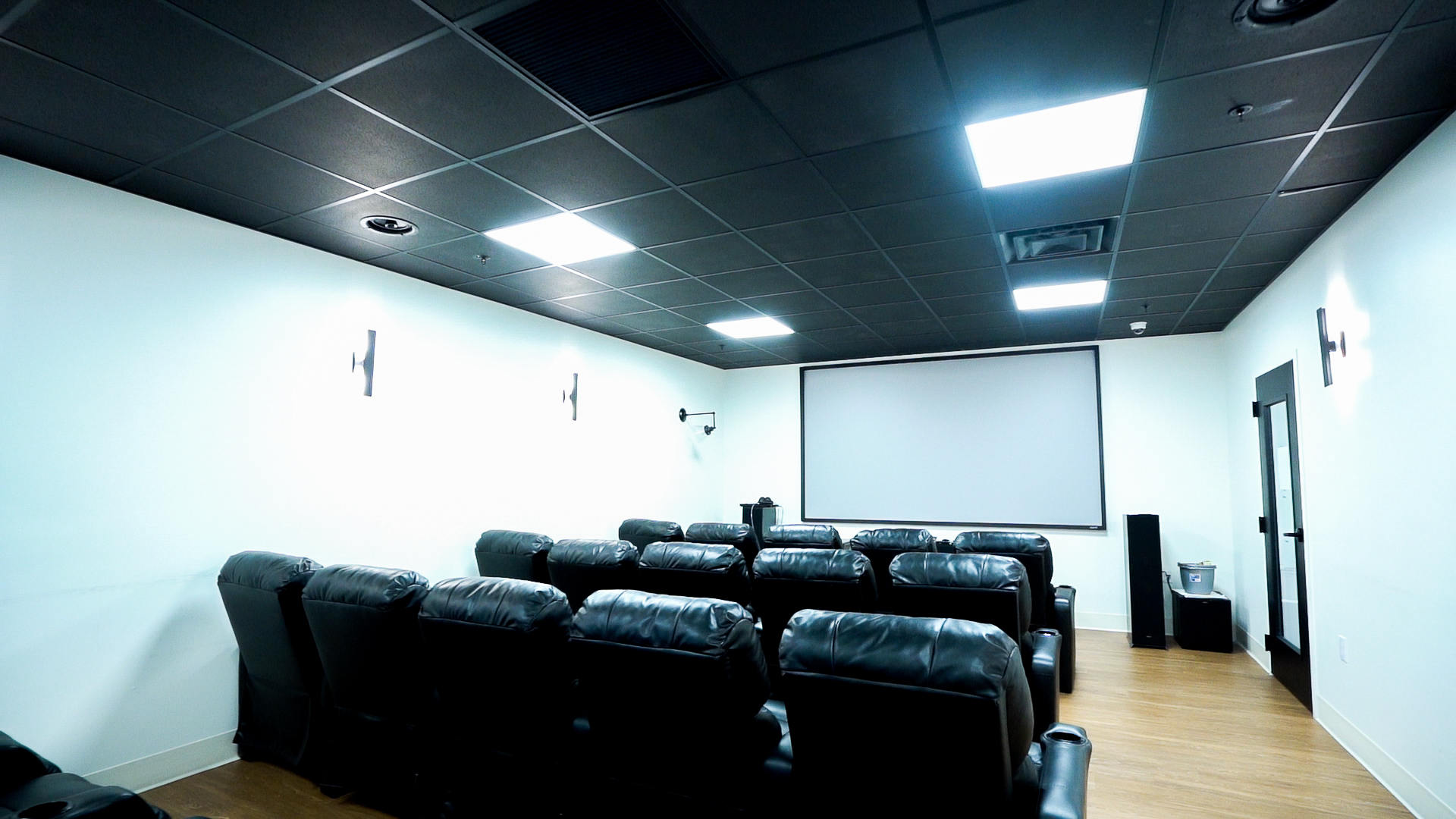 Small theater with leather recliners and screen