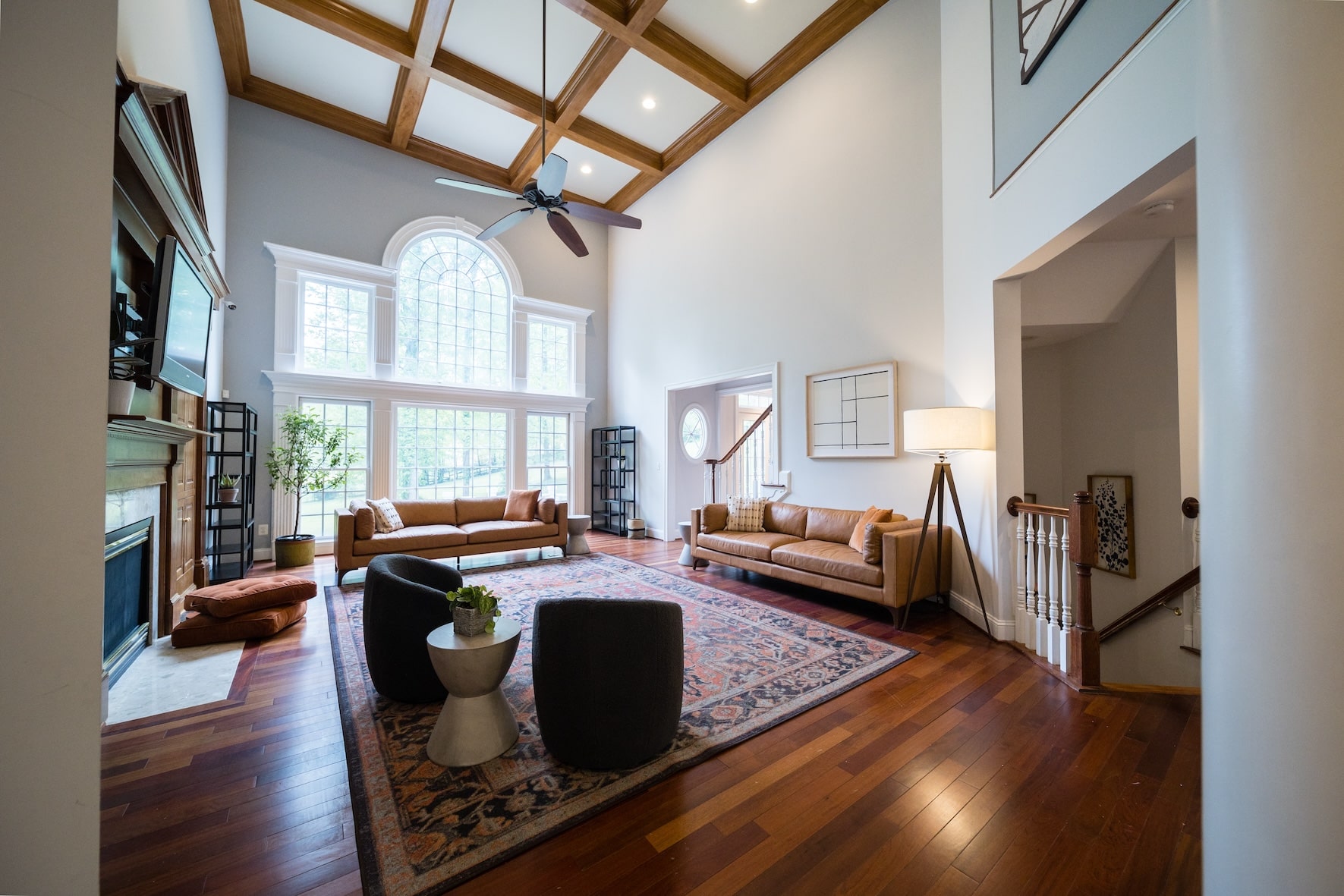 A high-ceiling living room with large windows and elegant furniture 