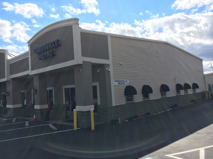 Facility driveway with black awnings and parking.
