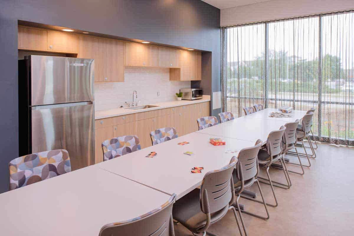 Meeting room with long table, chairs, and kitchenette