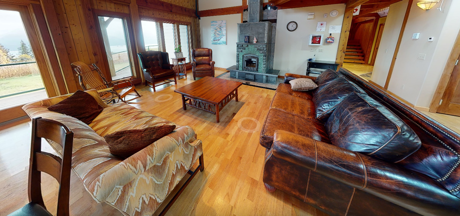 Living room with sofas, fireplace, and large windows