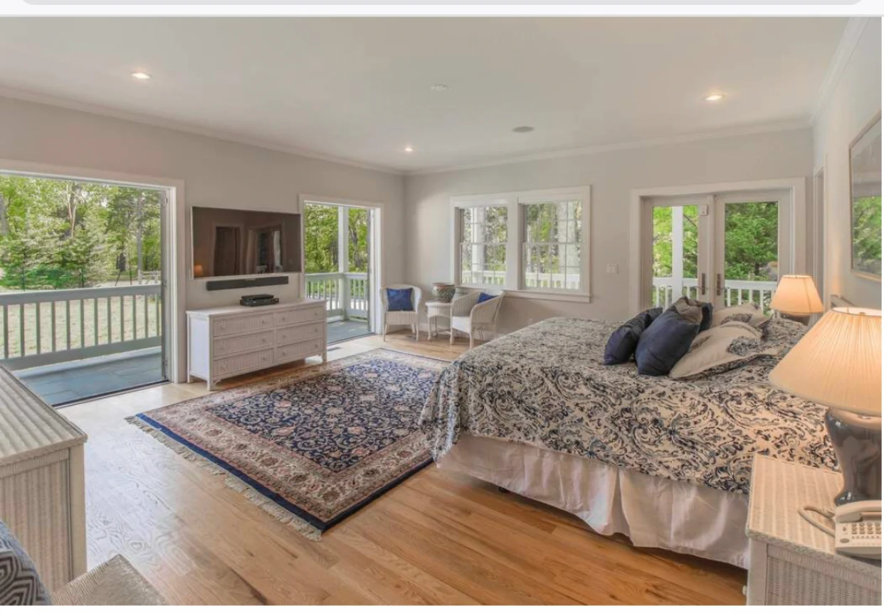 Spacious bedroom with large bed and balcony view