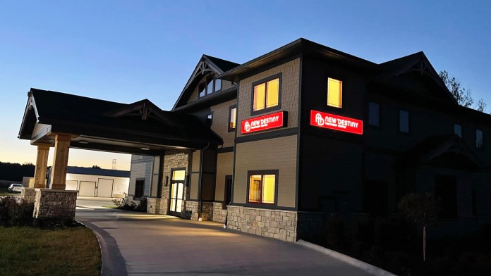 Exterior of New Destiny Treatment Center with lit signs at dusk.