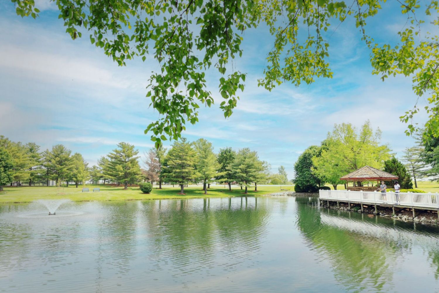 Outdoor area with gazebo, fountain by a pond.