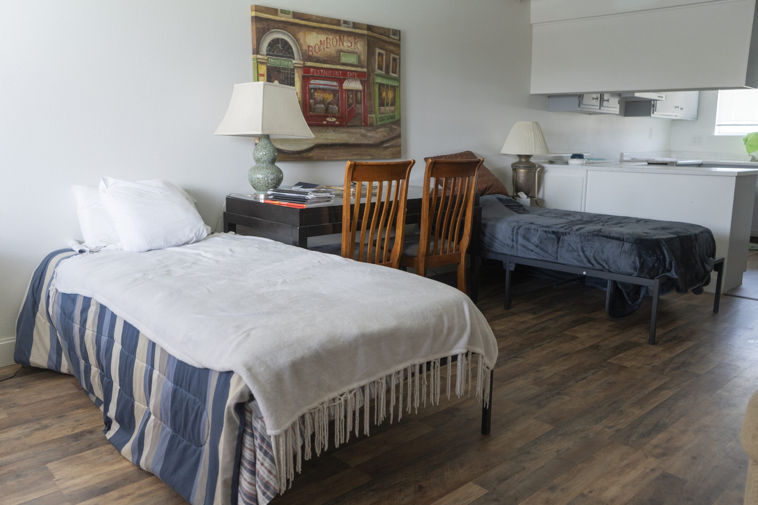 Two beds with chairs and table in shared bedroom setup