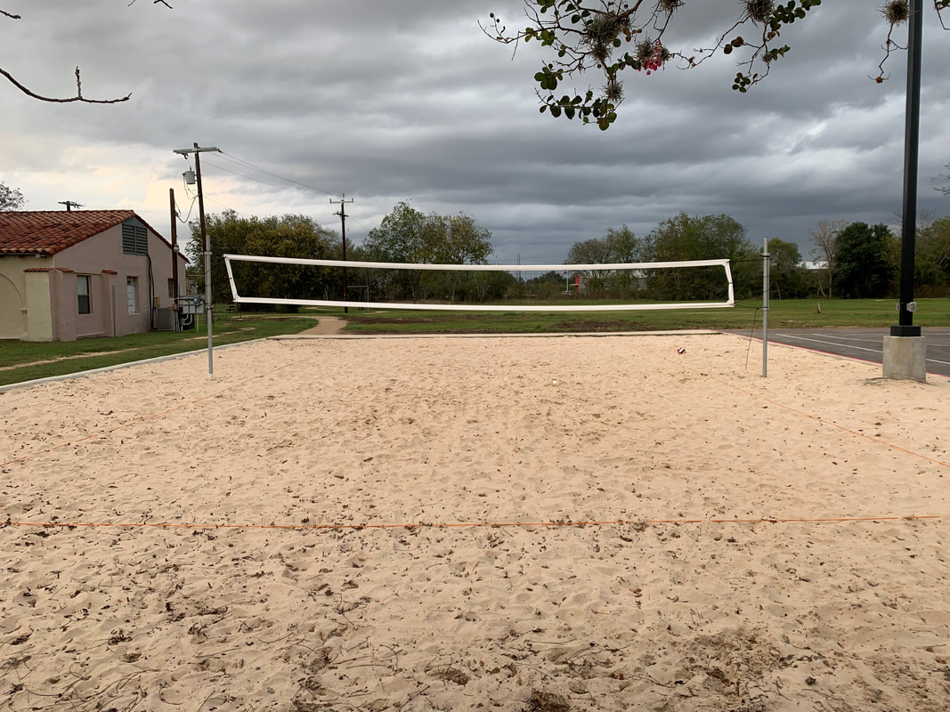 Outdoor sand volleyball court with net under cloudy sky