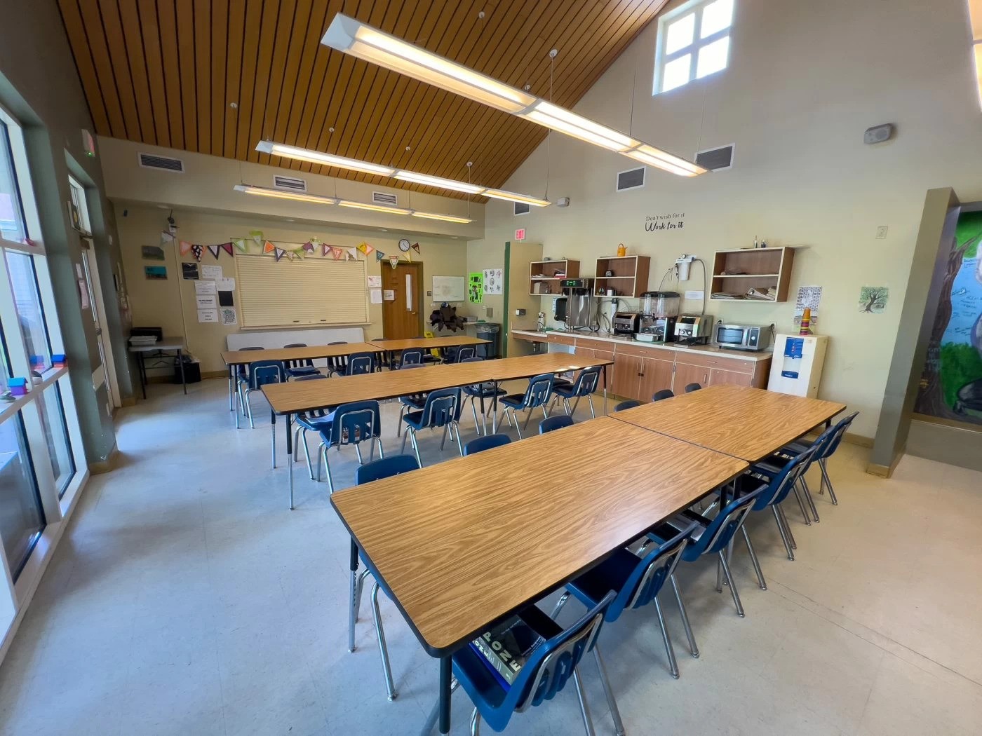 Cafeteria with long tables and beverage area