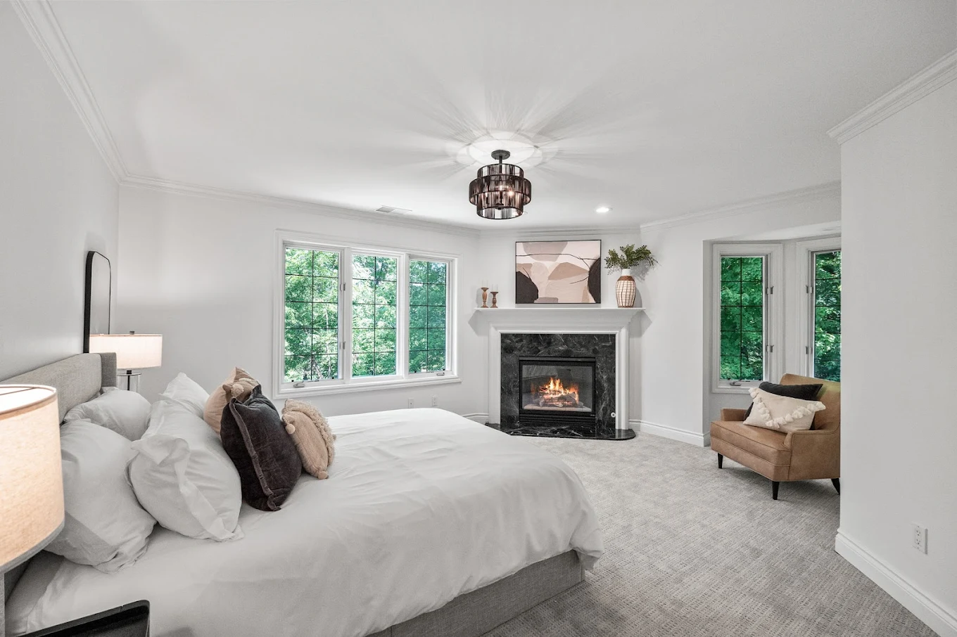 Cozy bedroom with fireplace and forest-facing windows