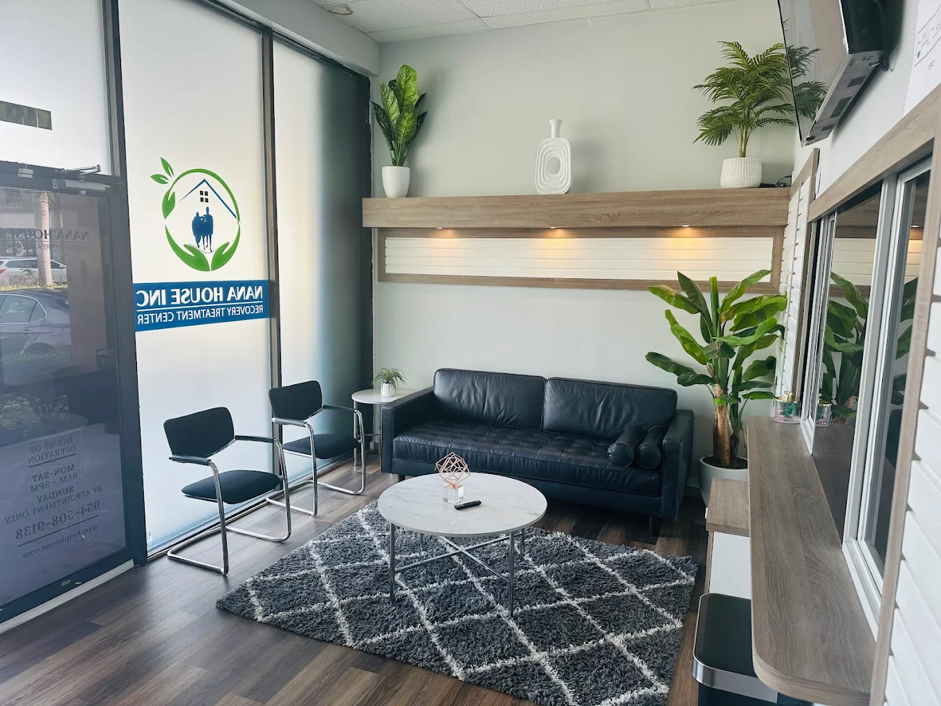 Rehab facility waiting area with sofa, chairs, and plants