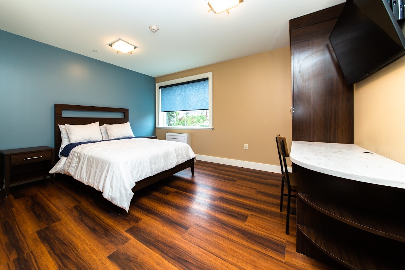 Bedroom with a window, wooden decor and side-table.