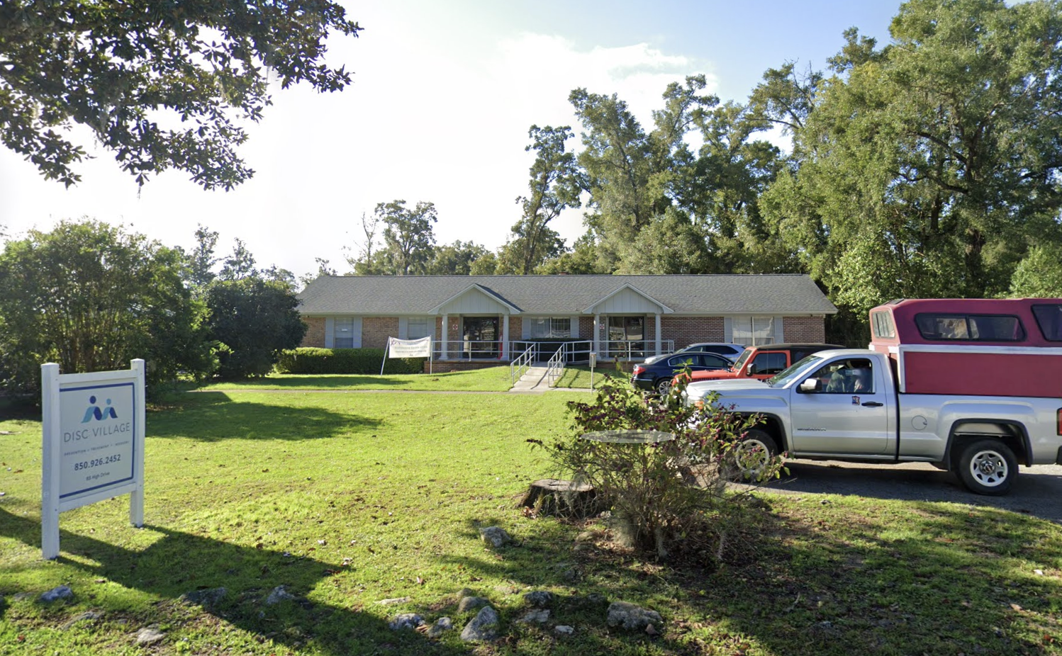 Wide view of Disc Village sign and building across grassy lawn