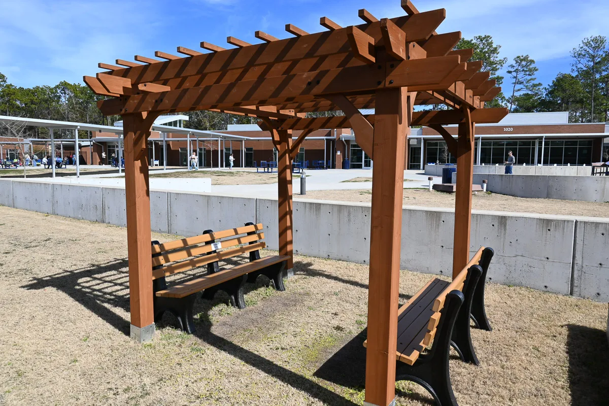 Wooden pergola with benches in the outdoor courtyard