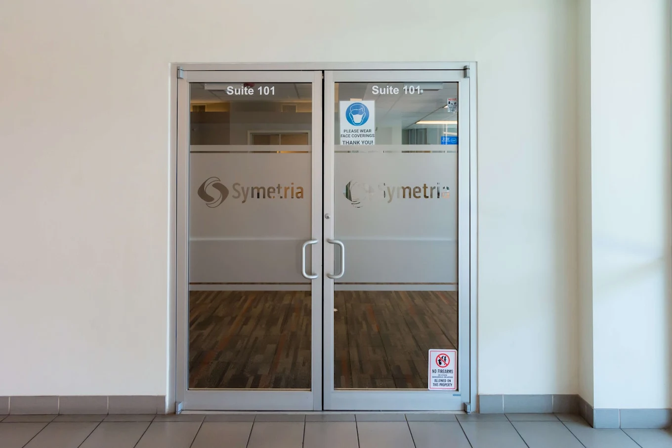 Glass entry doors with Symetria logo and signage