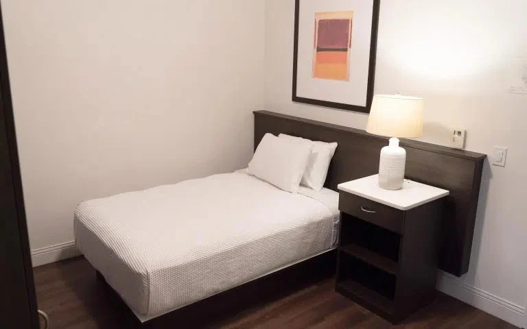 Single bed with nightstand and framed wall art