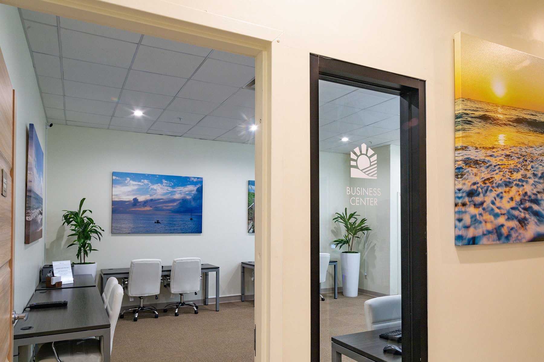Small office with desks and beach artwork