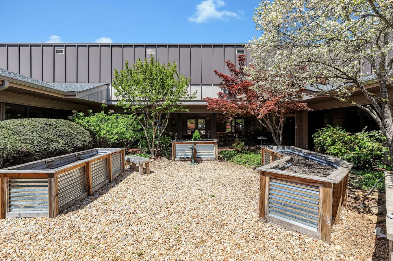 Courtyard with raised beds, trees, and a small fountain