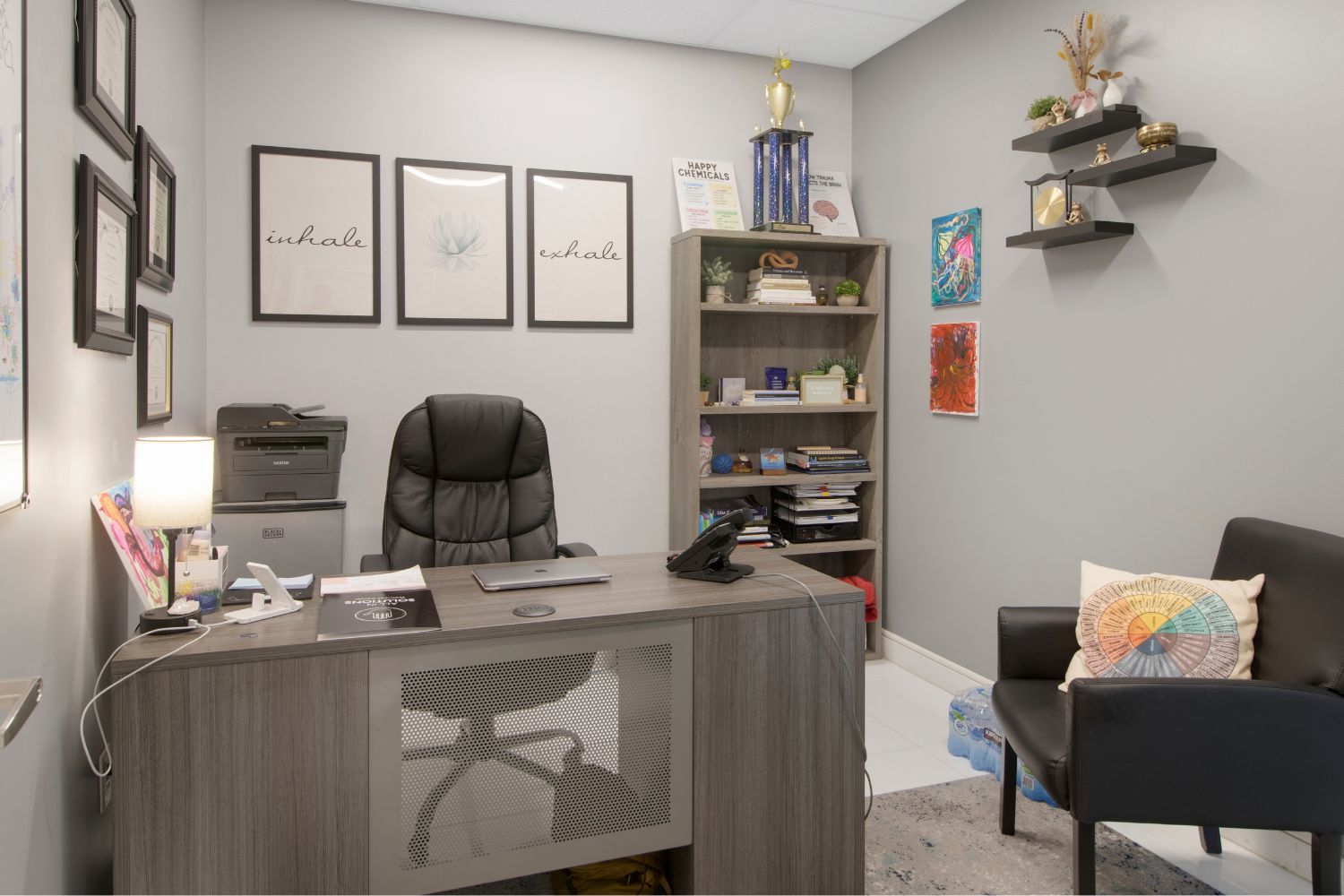 Desk with office chair, bookshelves, and wall art