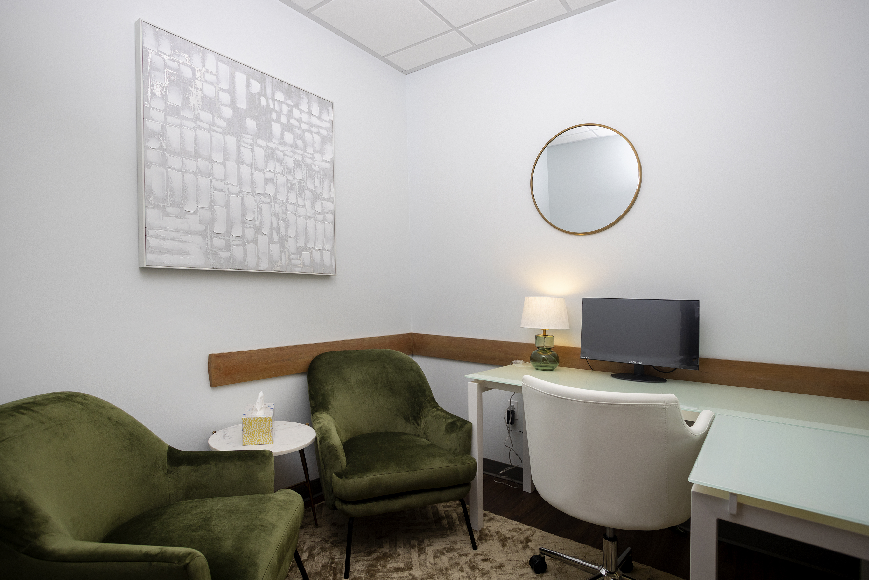 Green chairs and desk with computer in a private office