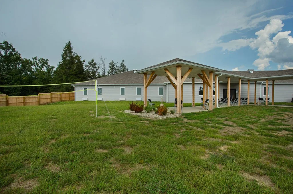 Grassy courtyard with covered seating and volleyball net