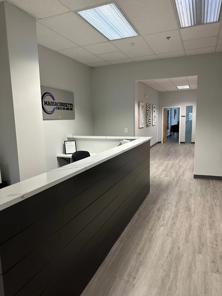 Reception desk at Massachusetts Center for Addiction with hallway and interior signage