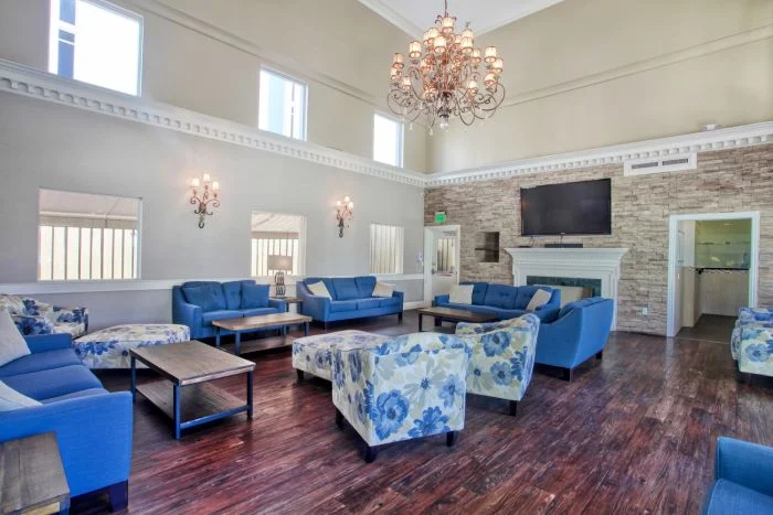 Spacious lounge with blue seating, chandelier, and fireplace