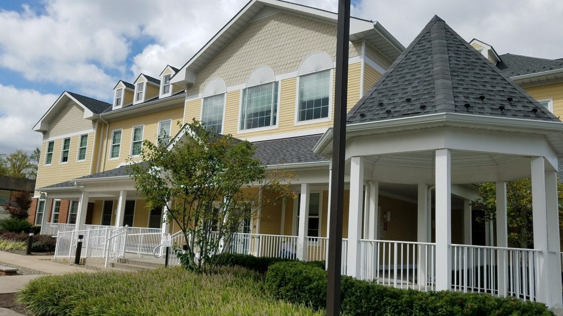 Yellow two-story building with gazebo and wraparound porch