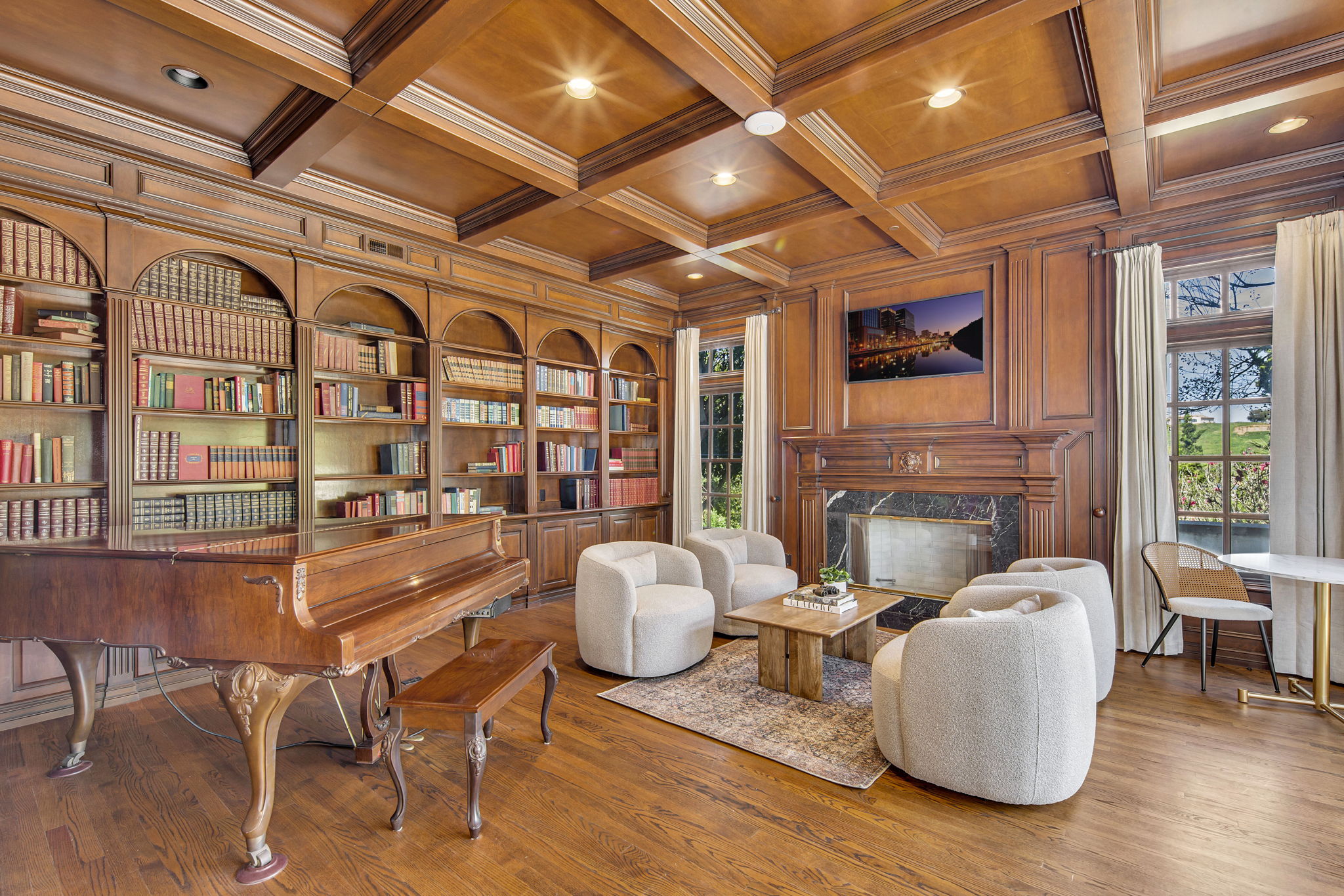 Wood-paneled library with piano and comfortable seating